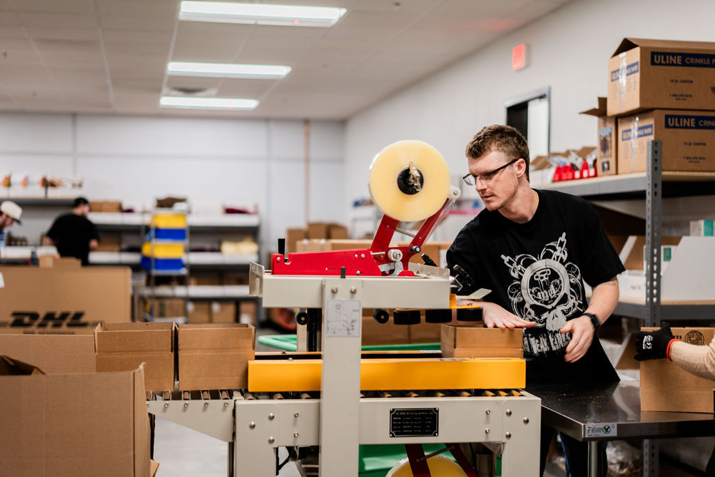 Uptime team member running the carton sealing machine on the shipping line in Draper, Utah