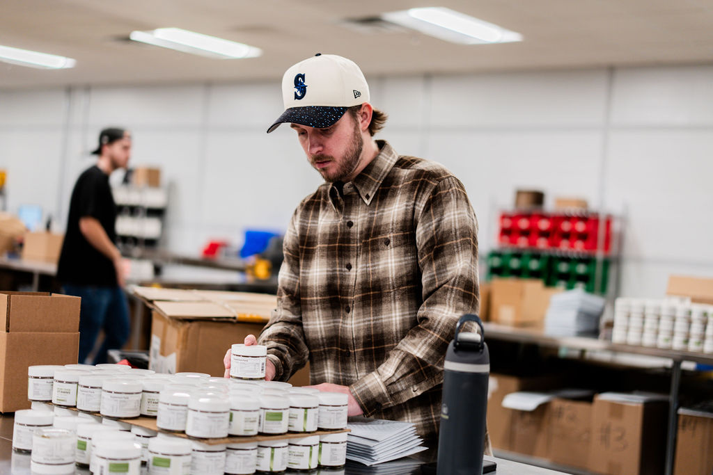 Uptime team member picking and packing supplement jars for ecommerce orders at the Draper, Utah fulfillment center